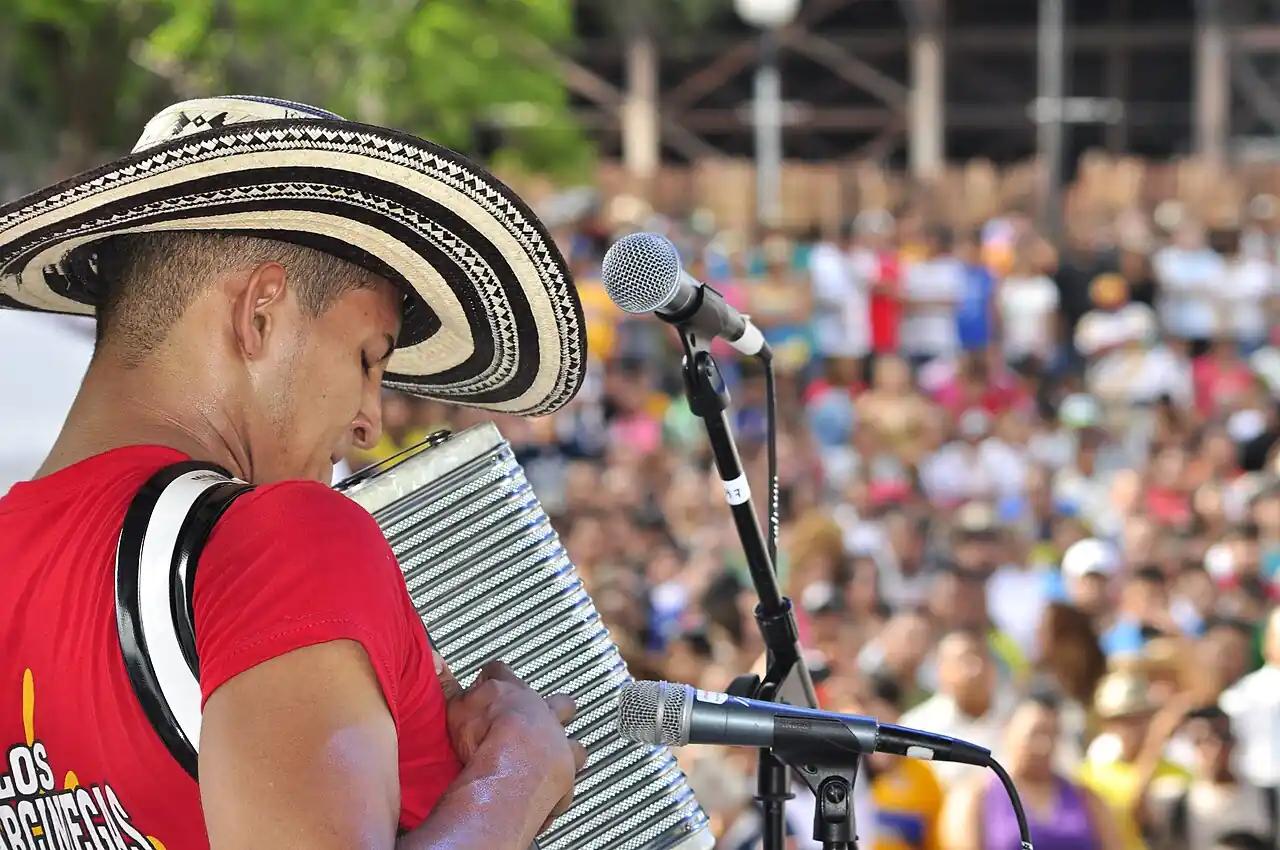 acordeonista en primer plano muy nítido, la multitud vibrante al fondo